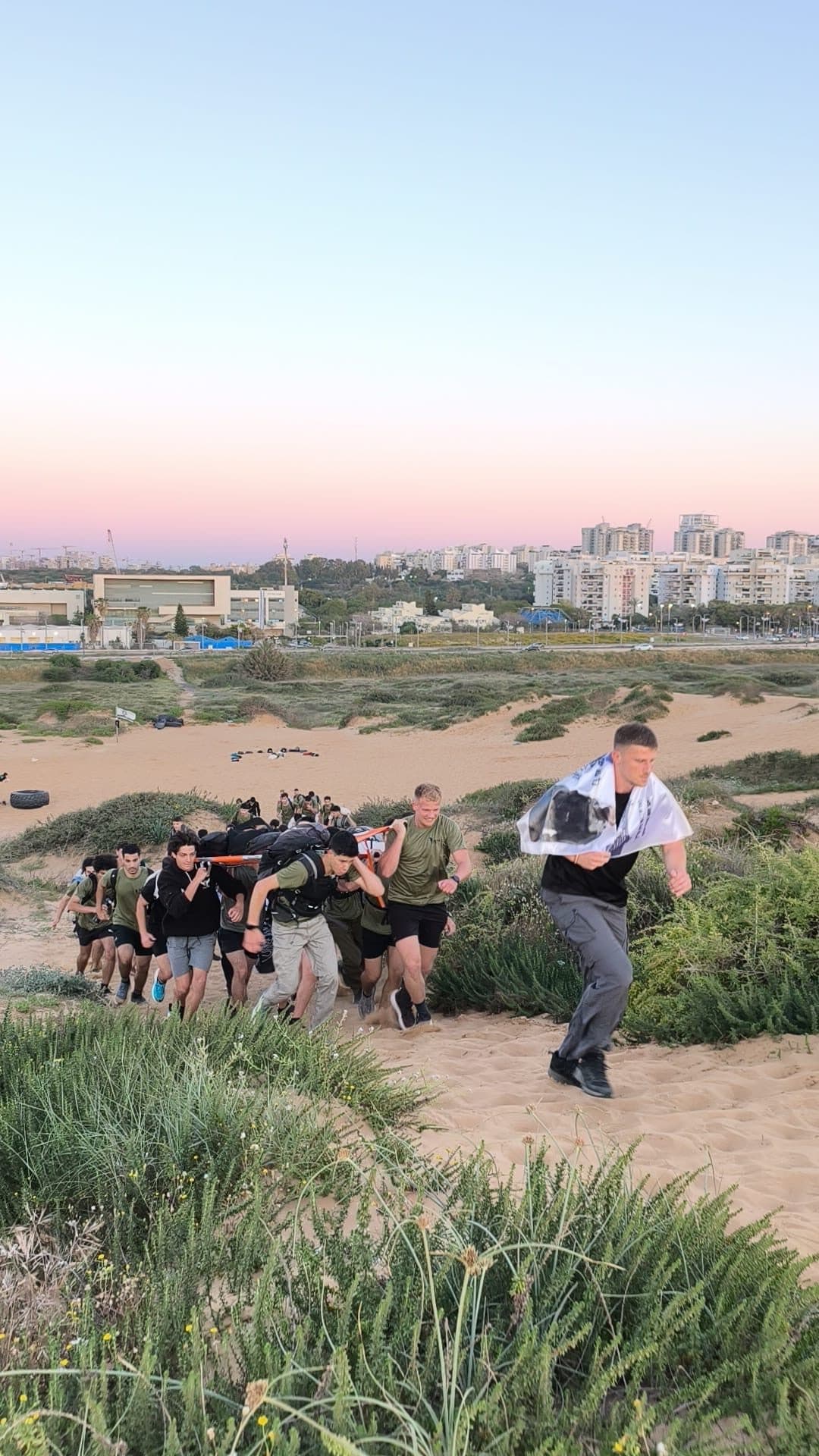 חניכי אדרנלין סוחבים אלונקה במעלה דיונה